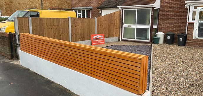 Wooden slatted fence with a sign reading 